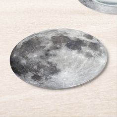 the moon is shown in front of a mirror on a wooden surface with two circular mirrors behind it