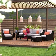 an outdoor living area with couches, tables and potted plants on the deck