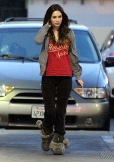 a woman walking down the street talking on her cell phone