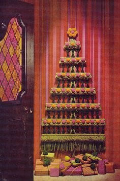 a large cake sitting on top of a table next to a wall with pink and yellow stripes