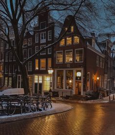 a street scene with focus on the building and bicycles parked in front of it at night