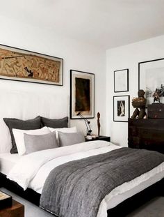 a bed sitting in a bedroom next to a dresser and pictures on the wall above it