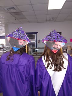 two girls wearing purple graduation gowns with hats on their heads and words written on them