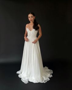 a woman in a white wedding dress posing for a photo with her hands on her hips