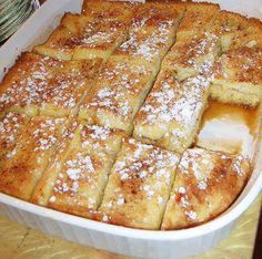 some food is in a white dish on a table and it has powdered sugar on top