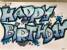 the word happy birthday written in blue and black ink on white paper with spray paint