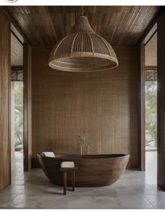 a large wooden bath tub sitting under a light fixture