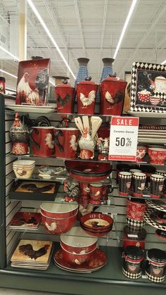 a display case filled with lots of red and white dishes on top of metal shelves