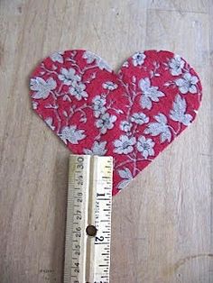 a heart shaped object with a measuring tape on it's side and a ruler in the foreground