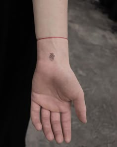 a person's hand with a small tattoo on it