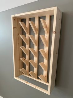 a wooden wine rack mounted to the side of a wall with shelves on each side