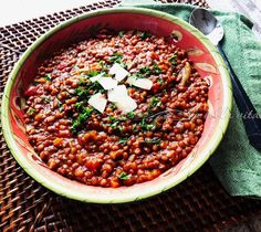 a bowl filled with lots of food sitting on top of a table next to a fork