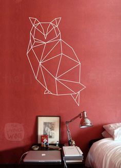 a bedroom with red walls and an owl wall decal