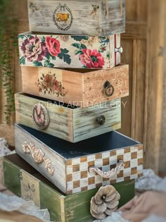 four wooden boxes stacked on top of each other with flowers painted on the lids and sides