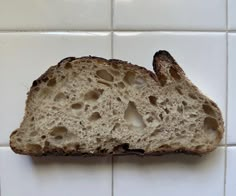 a piece of bread sitting on top of a white tile wall