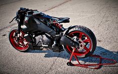 a black and red motorcycle parked on top of a parking lot