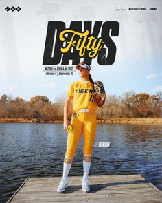 a man in yellow baseball uniform standing on a dock holding a ball and mitt