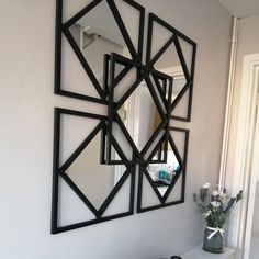 a mirror hanging on the wall next to a vase with flowers