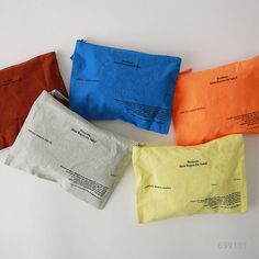 four different colored bags sitting next to each other on a white surface, with one bag in the middle