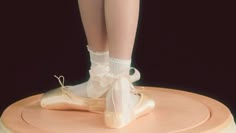 a ballerina's feet with white socks and ballet shoes on top of a cake