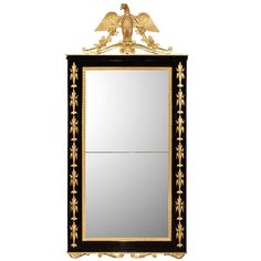 an ornate black and gold mirror with two birds on the top, one bird above it