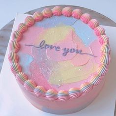 there is a pink cake that has the words love you on it