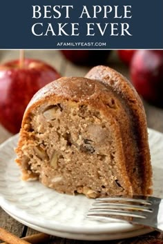 a piece of apple cake on a white plate with a fork and an apple in the background