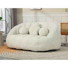 a white chair sitting on top of a rug in a living room next to a table