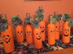 pumpkins with faces painted on them are lined up in the middle of a table