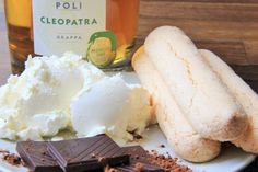 a plate topped with ice cream and chocolate next to a bottle of alcohol on a table