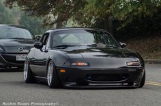 two black sports cars driving down the road