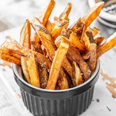 french fries in a black bowl on a table