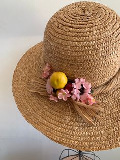 "This is a vintage 1950's straw sun hat. The hat is intricately woven with a braided section across the brim. There is also pink tone faux floral details. By the faux flowers there are also plastic faux fruit adding a pop of color and texture. The hat is in excellent condition. Measurements: Circumference: 21\" | Inside Depth: 5.5\" | Brim Depth: 4\" | Brim Circumference: 46\" Unless otherwise stated all vintage items are used and may have minor to moderate wear or discoloration considering the Bohemian Natural Panama Hat For Garden Party, Adjustable Pink Straw Hat, Bohemian Natural Straw Hat For Garden Party, Spring Pink Straw Hat, Pink Straw Fedora Hat, Spring Woven Hats For Garden Party, Woven Hat For Spring Garden Party, Pink Fedora Straw Hat, Bohemian Straw Hat With Short Brim For Garden Party