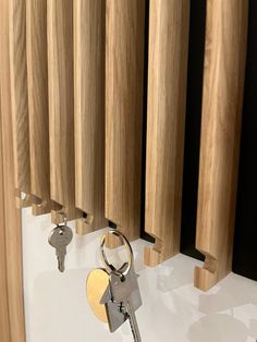 two keys are attached to the side of a wooden radiator with wood slats