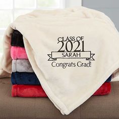 a stack of towels with the words class of 2020 on them sitting on top of a couch