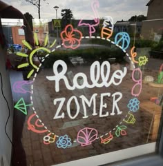 a window that has some writing on it in front of a storefront with the words ralleo zomer