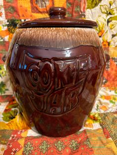 a ceramic jar with the word love on it sitting on a quilted tablecloth