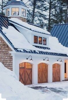 a white house with two garages covered in snow