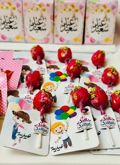 there are many candys on the table with tags in arabic and english writing that say happy valentine's day