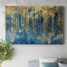 a blue and gold painting hanging on the wall in a living room with a couch