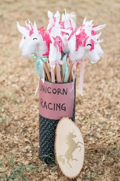 a vase filled with pink and white flowers sitting on top of a grass covered field