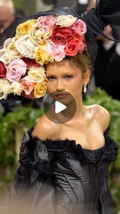 a woman with flowers on her head walking down the runway