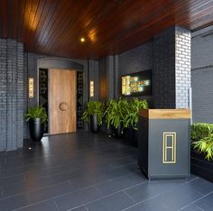 an entrance to a building with plants in black planters