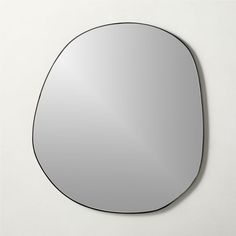 an oval mirror on the wall with no reflection in it, is shown against a white background