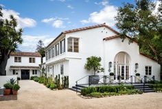 a white house with lots of windows and plants