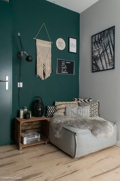 a bedroom with green walls and wooden floors