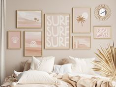 a bed topped with lots of pillows next to pictures on the wall above it and palm leaves