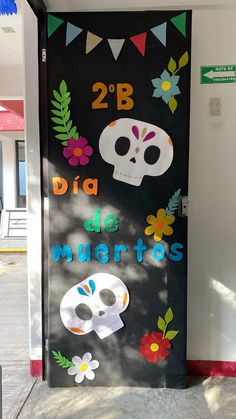 a door decorated with skulls and flowers on the side of a building that says dia de muertos