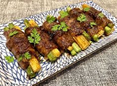 some meat and corn on a plate with garnishes in the middle, ready to be eaten