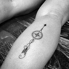 a small tattoo on the arm of a woman's left leg, with an arrow and star